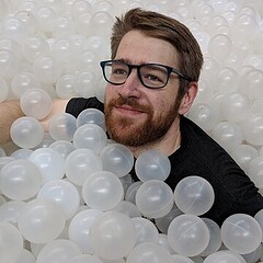 bearded man floating in a ball pit